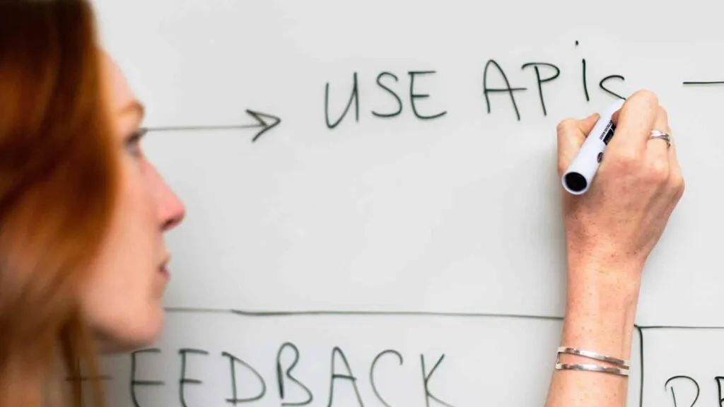 a woman writing on a whiteboard abstract of title