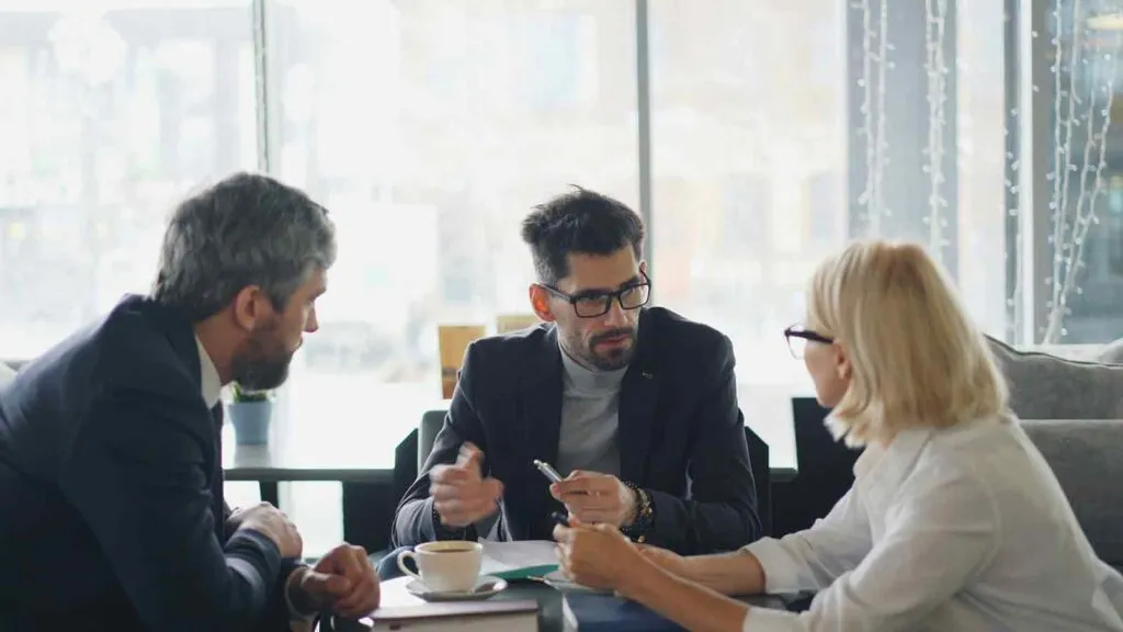 Three people reviewing portfolio title data during loan sale diligence
