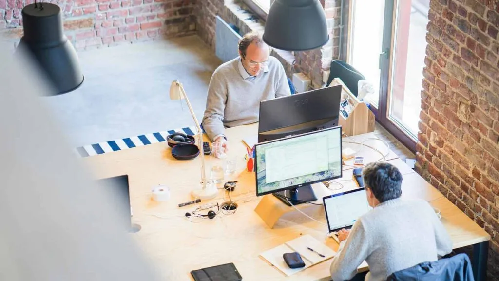 a group of people sitting at a table with computers mortgage loan lenders