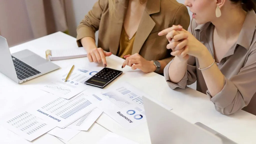 a woman pointing at a calculator webhooks